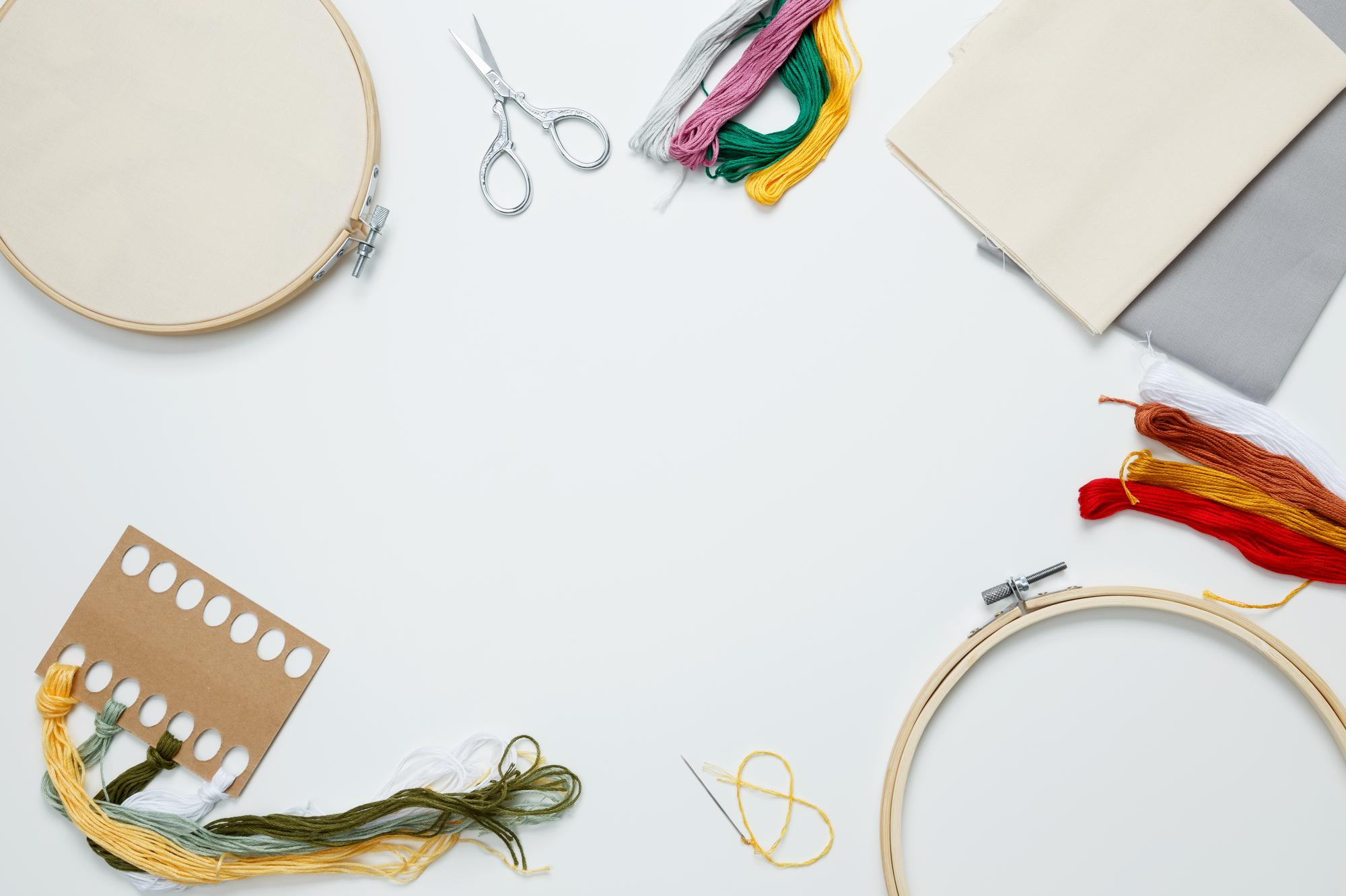 studio table with threads, hoops and patterns